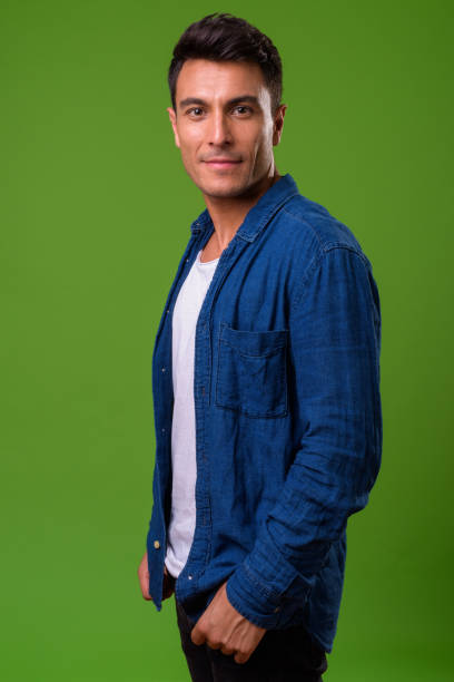 istock Young handsome Hispanic man against green background 964162534