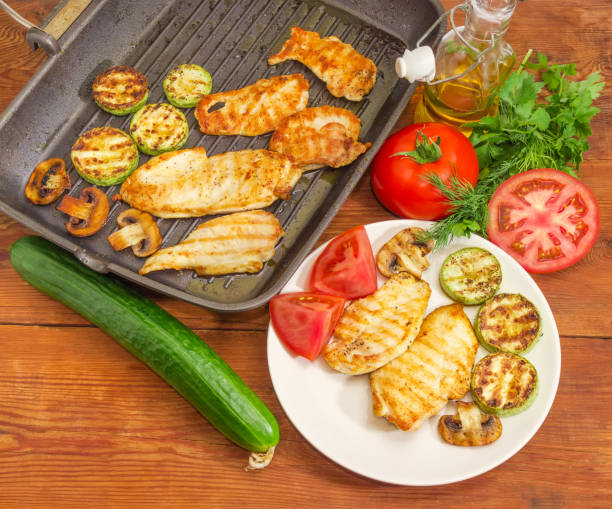 istock Grilled white meat on dish and grill pan, vegetables, greens 964162854