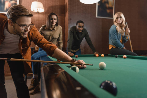 istock young attractive multiethnic friends playing in pool at bar 964163086