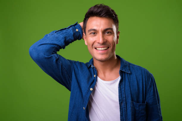 istock Young handsome Hispanic man against green background 964163164
