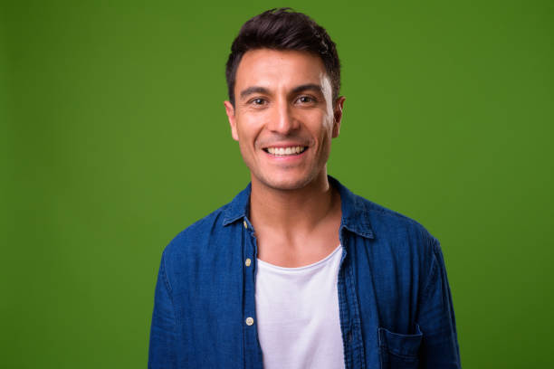 Young handsome Hispanic man against green background Studio shot of young handsome Hispanic man against chroma key with green background chilean ethnicity stock pictures, royalty-free photos & images
