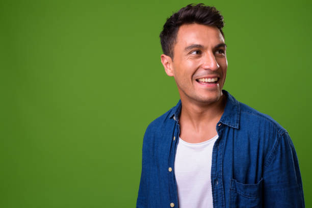istock Young handsome Hispanic man against green background 964163284
