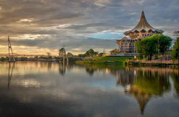 Riverfront at Kuching Borneo The waterfront of the Sarawak River with pedestrian bridge and National Assembly Building in Kushing Malaysia kuching waterfront stock pictures, royalty-free photos & images
