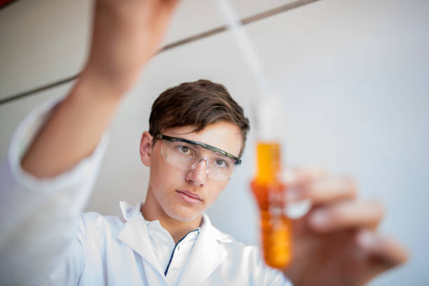 studente del liceo gocciola liquido in provetta - laboratory test tube student scientist foto e immagini stock