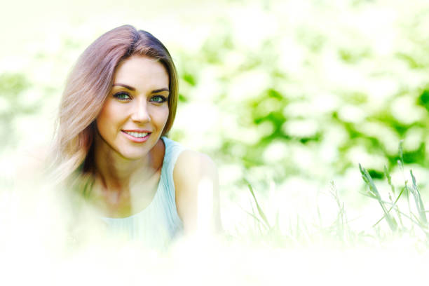 beautiful young woman in blue dress lying on grass