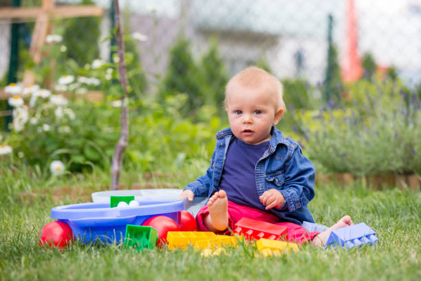 istock Little baby boy, playing with big construction blocks in garden 964186094
