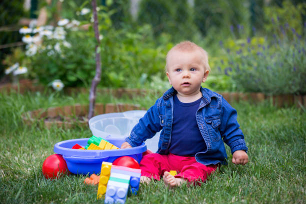 istock Little baby boy, playing with big construction blocks in garden 964186688