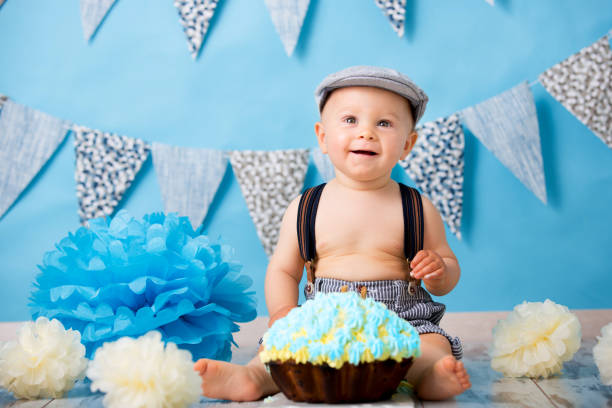 kleinen jungen, feiert seinen ersten geburtstag mit smash kuchen party, studio isoliert schüsse aufs blau - birthday first place cake symbol stock-fotos und bilder