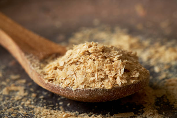 Nutritional brewers yeast flakes Closeup of nutritional brewers yeast flakes in wooden spoon yeast stock pictures, royalty-free photos & images