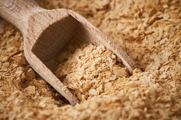 Nutritional brewers yeast flakes Closeup of nutritional brewers yeast flakes with wooden scoop bakers yeast stock pictures, royalty-free photos & images