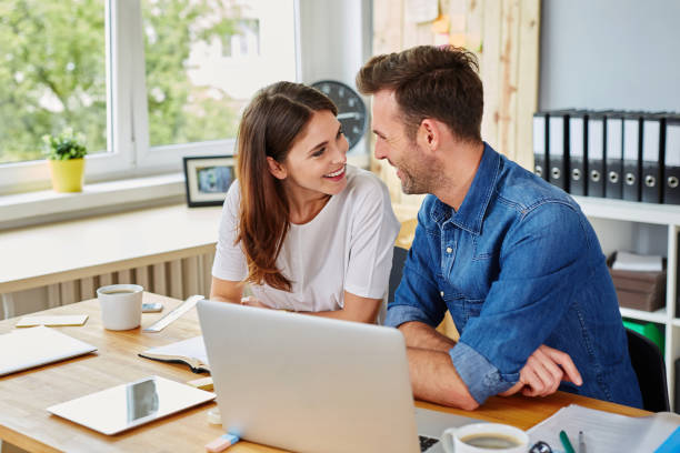 istock Happy couple working together at office looking at each other 964192404