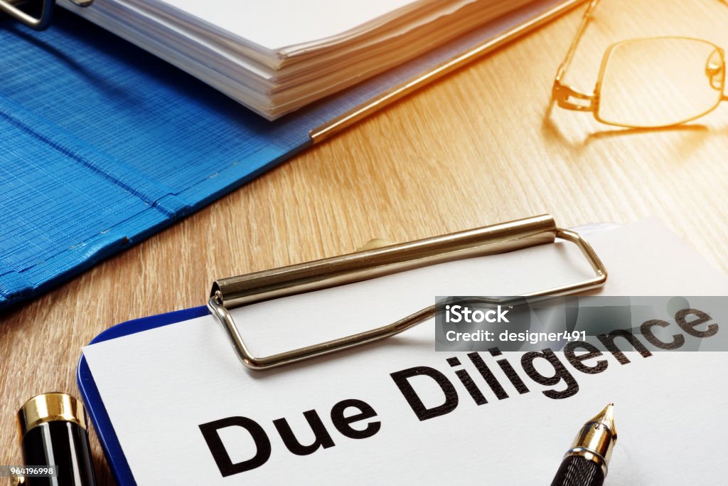 Document with title Due Diligence on a desk. Efficiency Stock Photo