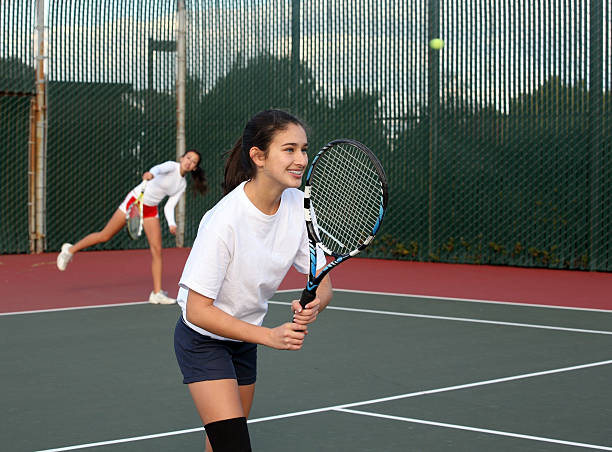 Girls playing tennis stock photo