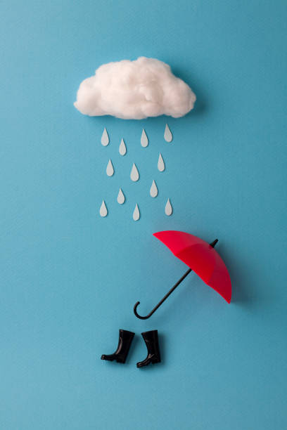 paraguas y la lluvia botas debajo de la nube sobre fondo azul de cielo - white mid air rain wind fotografías e imágenes de stock