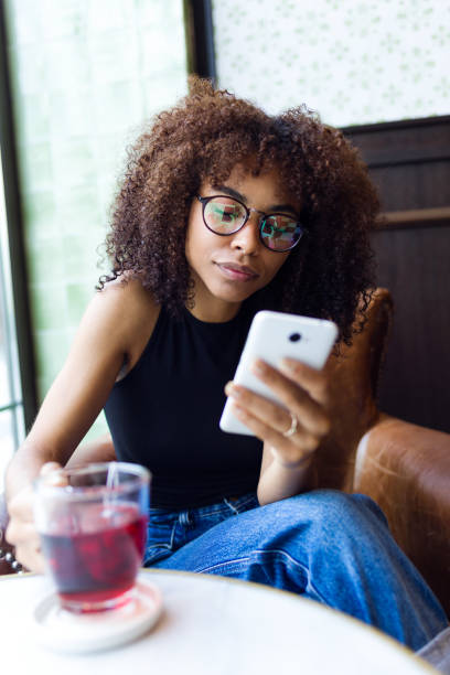 istock Beautiful young woman using her mobile phone in cafe. 964215776