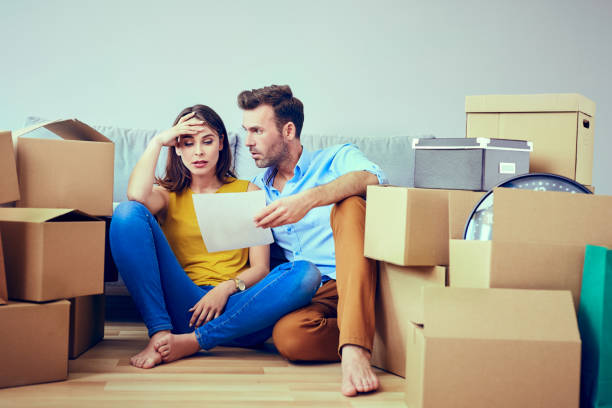 Worried couple reading agreement after moving to new home stock photo