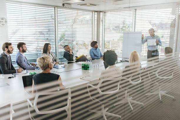 istock Male CEO talking about business progress on a presentation in a board room. 964216534
