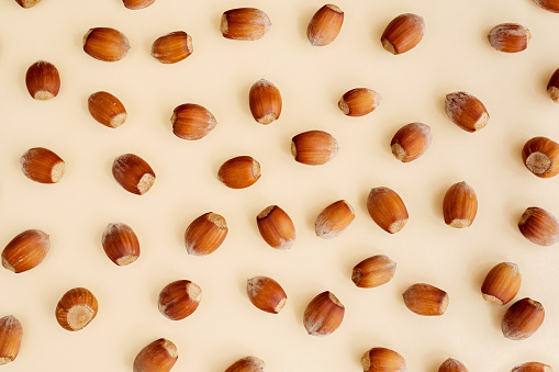 Hazelnuts on yellow background, flatlay, top view