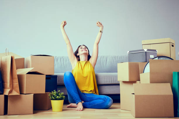 Happy young woman moving to new home - having fun Happy young woman moving to new home - having fun unpacking photos stock pictures, royalty-free photos & images