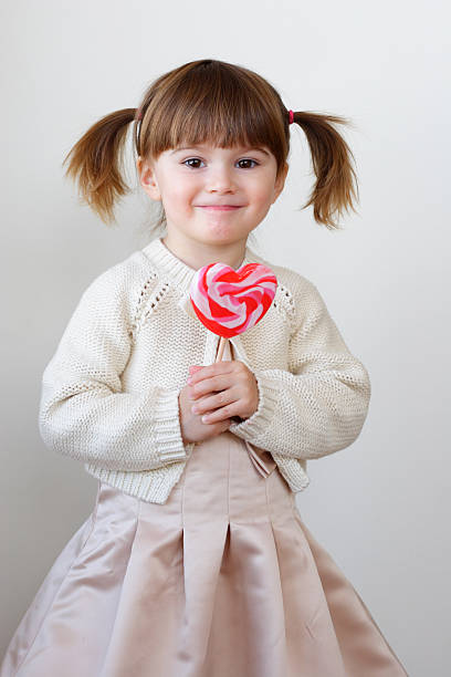 menina e um pirulito - child valentines day candy eating - fotografias e filmes do acervo