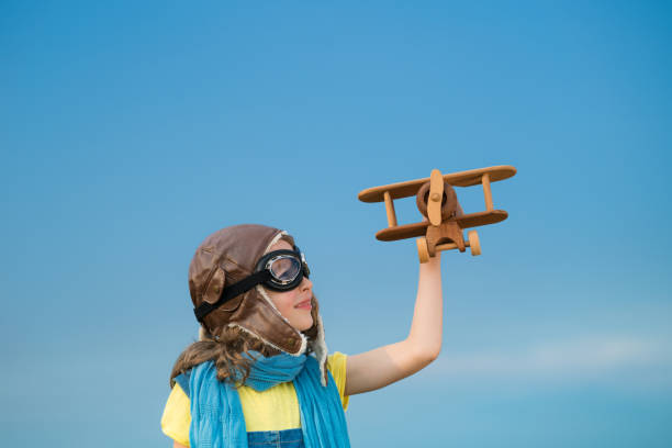 istock Happy kid playing with airplane outdoors 964236494