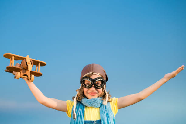 istock Happy kid playing with airplane outdoors 964236520