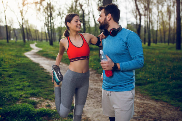 istock Fit athlete couple doing stretching exercises on running track 964240532