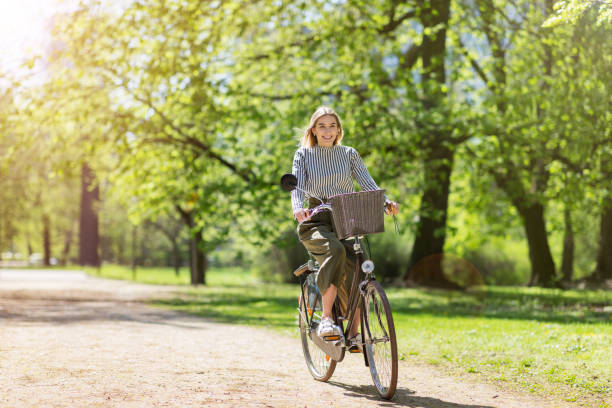 istock Attractive young woman cycling through the park 964240846