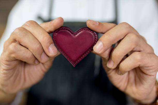 Close up of a craftsman holding a leather heart   Okayama, Japan.