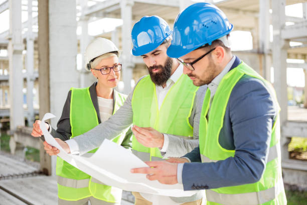 istock Group of architects or business partners having meeting on a construction site 964244476