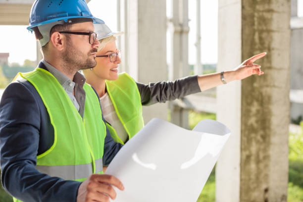 istock Young female architect pointing at something to her colleague at a construction site 964244516