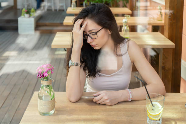 istock Sad girl with phone in cafeteria 964255690