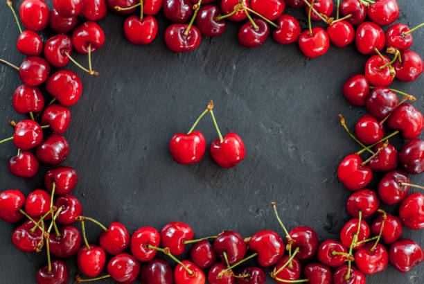 istock cherries arranges as a frame on black with cherries in the middle concept photo 964255866