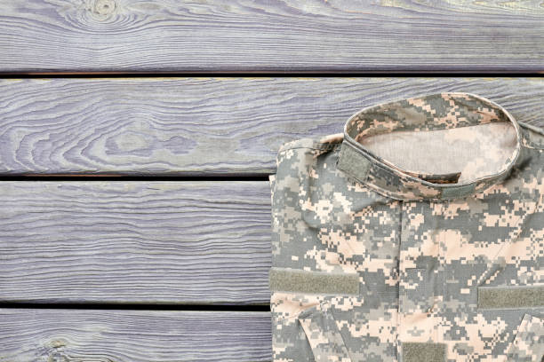 istock Top view camouflage jacket on wood. 964256234