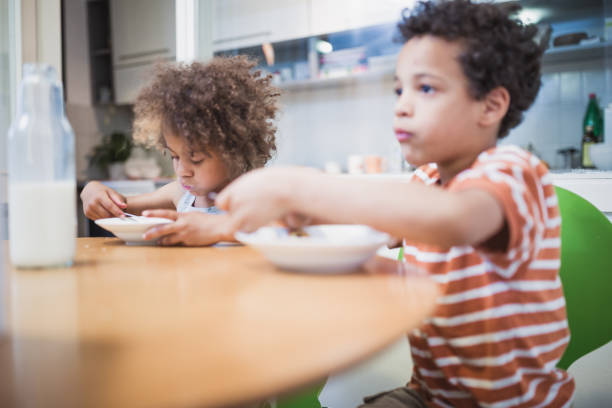 istock Cute mixed - race siblings having breakfast at home 964259166