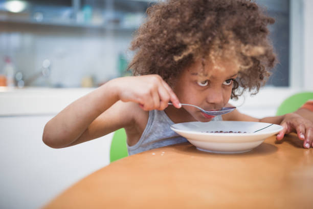 istock Cute mixed - race siblings having breakfast at home 964260836