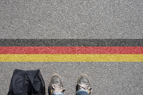 A man with a suitcase stands on the border with Germany stock photo