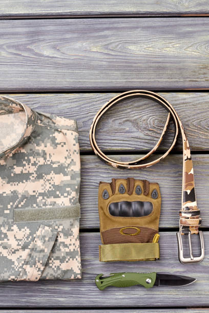 istock Twisted belt, glove, pocket knife and camouflage jacket. 964268202