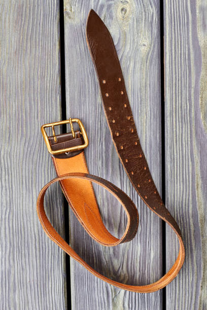 istock Twisted orange belt on wood. 964271388