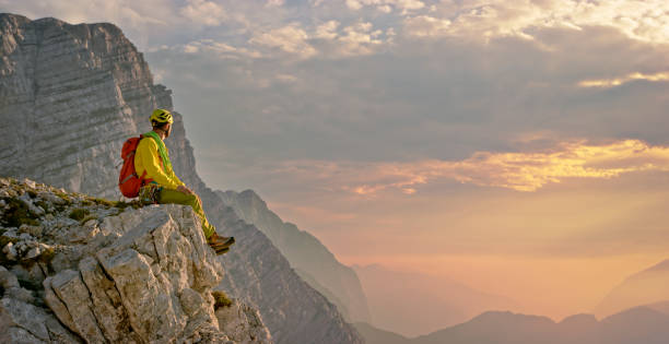 istock Mountaineer sitting on edge of mountain 964273818