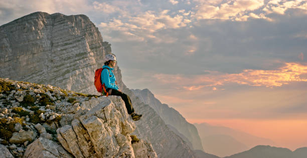 istock Mountaineer sitting on edge of mountain 964273826