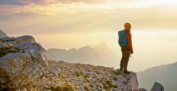 istock Mountaineer standing on edge of mountain 964273828