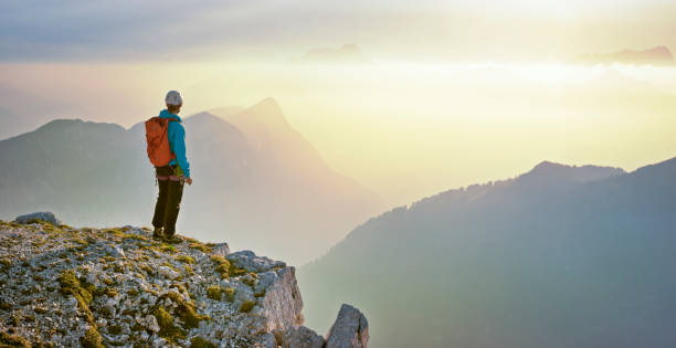 istock Mountaineer standing on edge of mountain 964273830