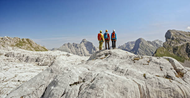 istock Mountaineers standing on top of mountain 964273934