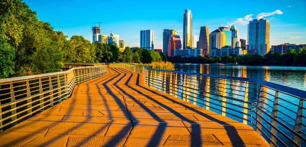 Austin Texas Abstract Lines leading into the Skyline Austin Texas Abstract Skyline Cityscape as the sunrise hits the riverside pedestrian bridge modern architecture creates an amazing display of shadows across the bridge leading up to the skyline downtown footbridge photos stock pictures, royalty-free photos & images