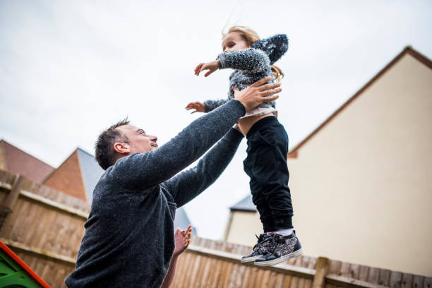 istock Father lifting his daughter in the air playfully 964276502