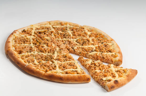 Pizza baked in the oven with tomato sauce and covered with mozzarella cheese, a, grated tuna , creamy curd cheese and oregano.