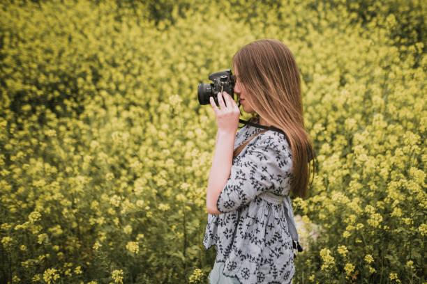 istock Young woman taking a picture with a DSLr camera 964278780