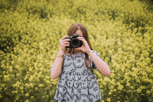 istock Young woman taking a picture with a DSLr camera 964278786