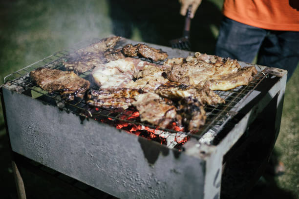 istock Midsection Of Man Preparing Meat On Barbecue Grill 964282130